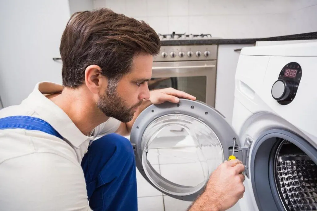 Appliance repair technician inspecting a front-load washing machine during same-day service in North Myrtle Beach, SC