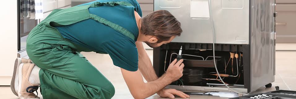 Technician inspecting refrigerator components during professional appliance repair in Murrells Inlet