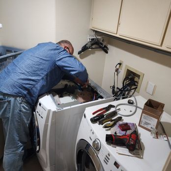 Technician diagnosing a washing machine during an appliance repair service call in Pawleys Island, SC