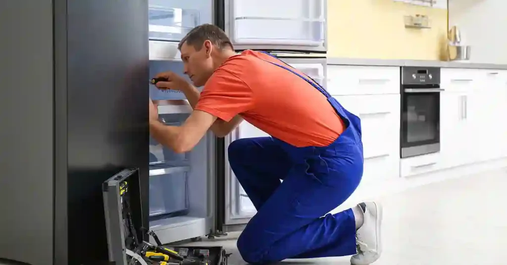 Technician performing refrigerator maintenance and diagnostics in a residential kitchen in Murrells Inlet, SC